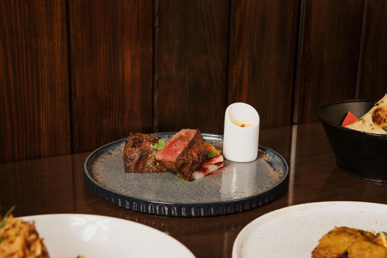 The Lalit London Hotell Exteriör bild A plate of grilled lamb